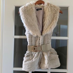 Beige cozy faux fur vest with gold colored belt and zipper pockets on front